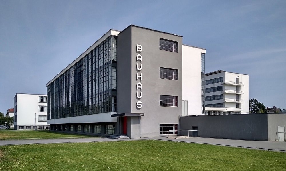 The Bauhaus building in Dessau, Germany, with a glass curtain wall, flat roof, and white unornamented facades